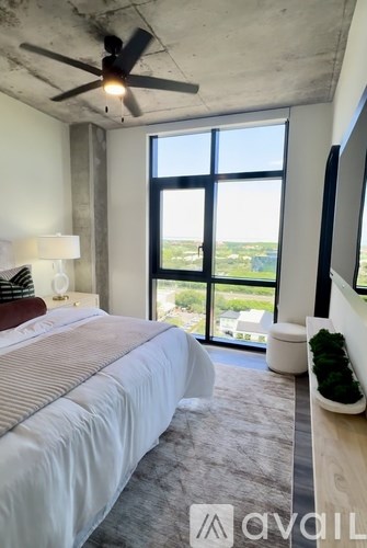 A bedroom with a large bed and a ceiling fan.
