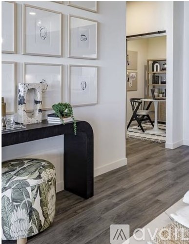 A living room with a black and white sofa and a green plant on the side table.
