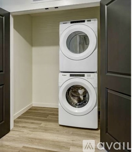 A white front load washing machine in a laundry room.