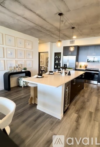 A modern kitchen with a white island and wooden floors.