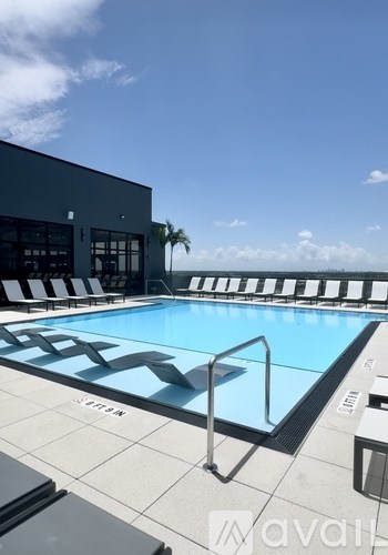 A swimming pool with a metal ladder and a building in the background.
