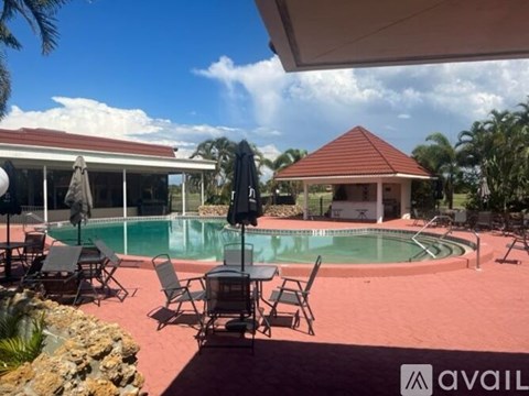 A pool area with chairs and a table.