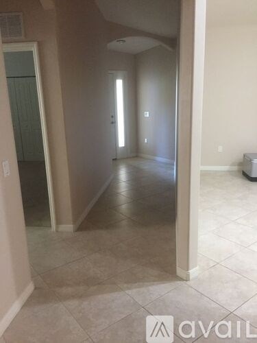 A hallway with tiled floors and white walls.