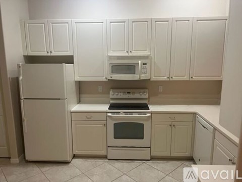 A kitchen with white appliances and cabinets.