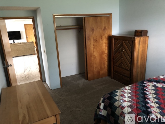 A room with a bed, a wooden table, and a wardrobe.
