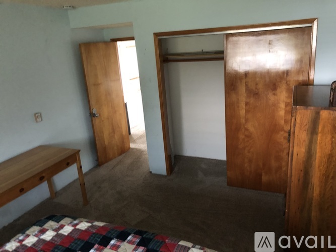 A room with a bed, a bench, and a wardrobe.