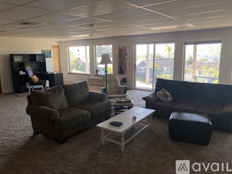 A living room with a brown couch, a grey couch, and a white coffee table.