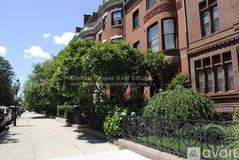 A street view of a residential area with a sign for "Boston Trooper Real Estate" in the foreground.