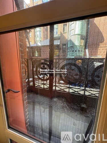 A window with a view of a cityscape and a sign for Boston Prop Real Estate.