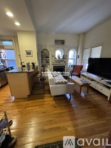 A living room with a couch, a chair, and a television.