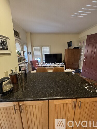 A kitchen with granite countertops and wooden cabinets.