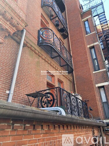 A red brick building with a balcony and a sign that says "Boston Pepper Boat Estate".