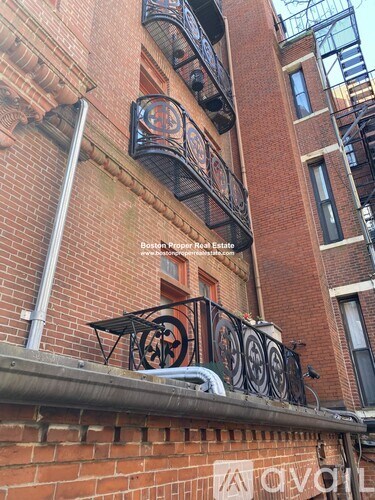 A red brick building with a balcony and a sign that says "Boston Pepper Boat Estate".