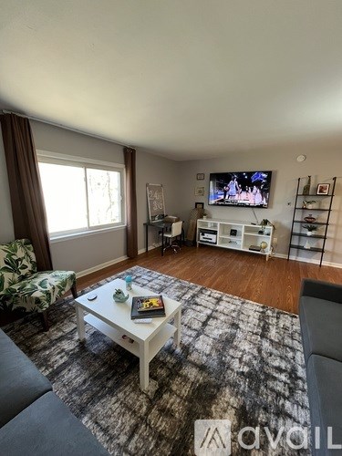 A living room with a white coffee table and a television on a stand.