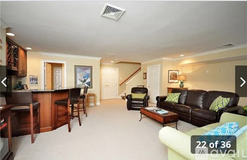 A living room with a brown leather couch and a wooden bar.