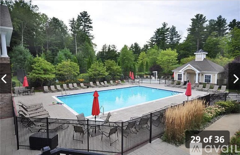 A pool surrounded by trees and chairs.