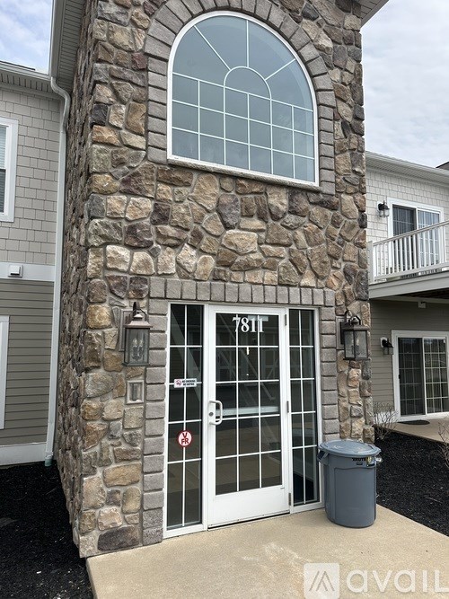A stone pillar with a glass window and a door with a glass window and a sign on it.