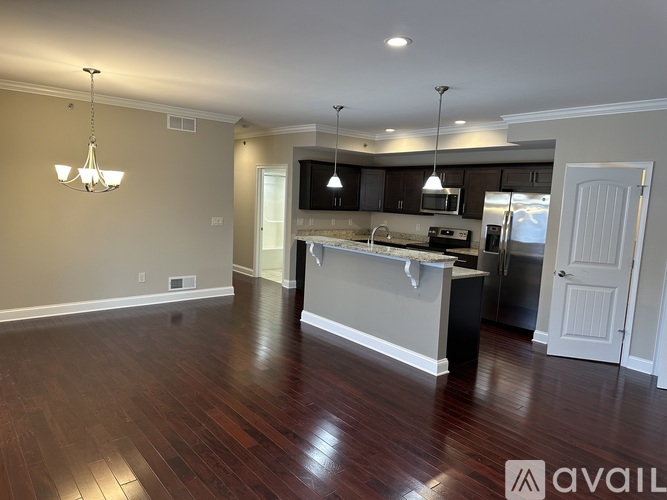 A spacious kitchen with dark wood floors and a central island.