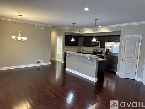 A spacious kitchen with dark wood floors and a central island.