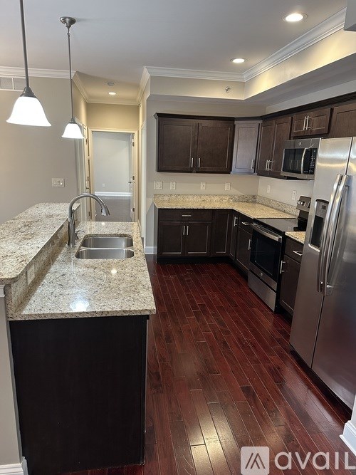 A kitchen with a granite countertop and stainless steel appliances.