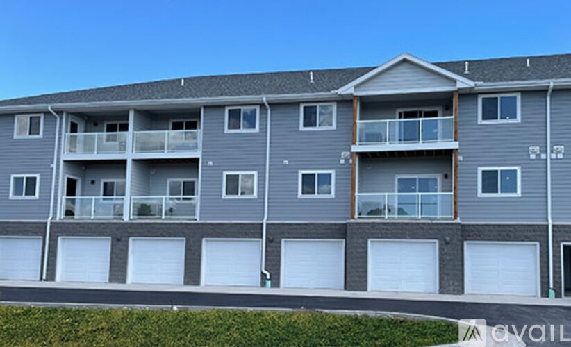A grey apartment building with a balcony on the second floor.