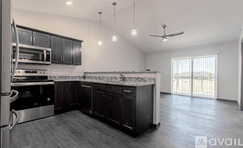 A modern kitchen with dark wood cabinets and stainless steel appliances.