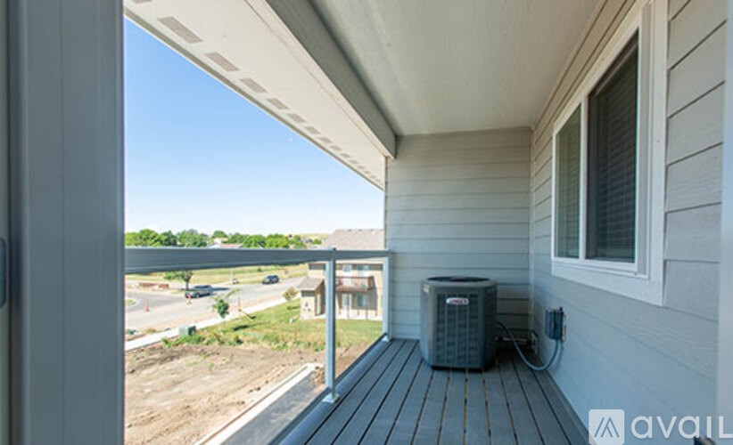 A balcony with a window and an air conditioning unit.