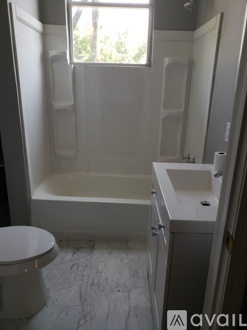 A white toilet sits next to a bathtub in a bathroom.