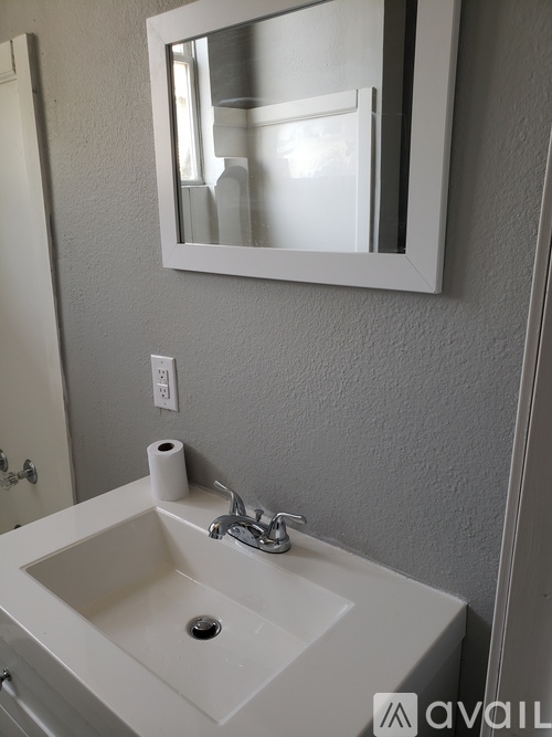 A white sink with a mirror above it.