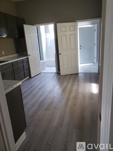 A kitchen with dark wood cabinets and white doors.