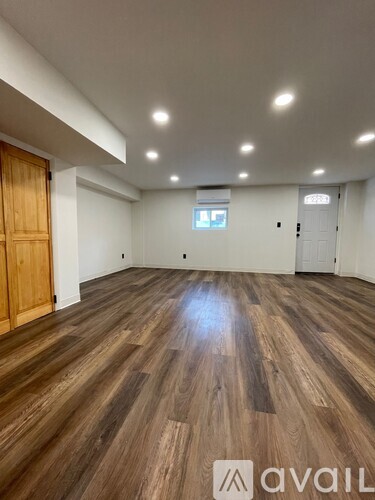 A room with wooden flooring and a window in the middle.