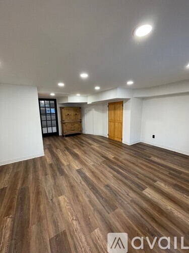 A room with wooden flooring and two doors.