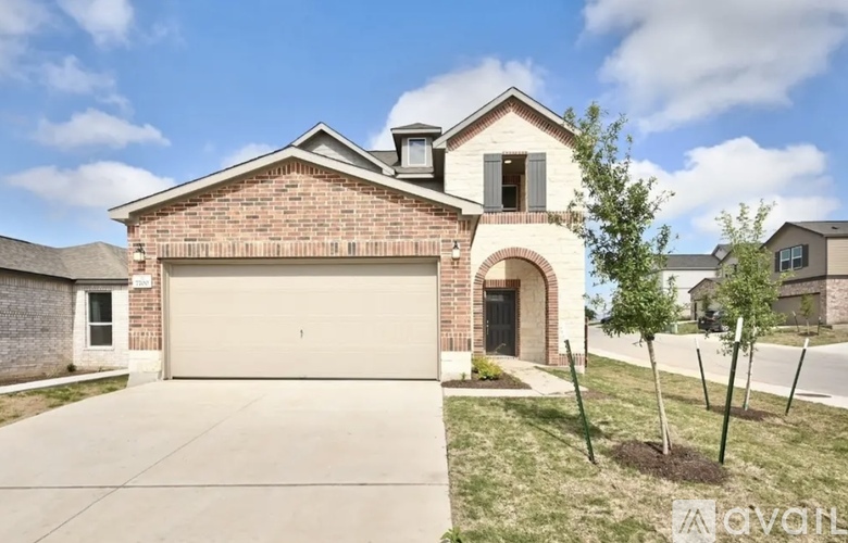 A brick house with a garage door and a driveway.