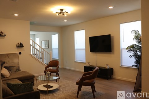 A living room with a brown chair and a black television.