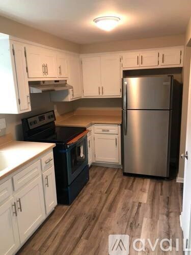 A kitchen with white cabinets and a black oven.