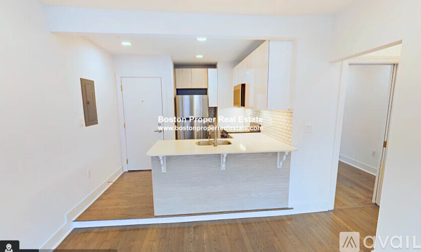 A kitchen area with a white countertop and a sink.