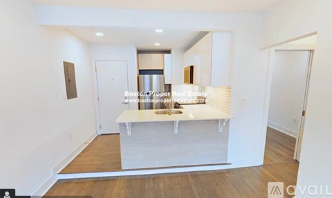 A kitchen area with a white countertop and a sink.