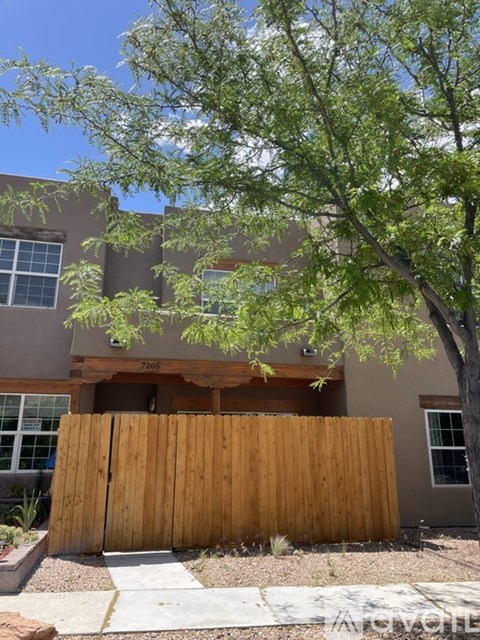 A brown wooden fence in front of a house.