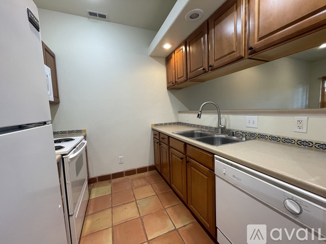 A kitchen with a white refrigerator, white oven, and white dishwasher.