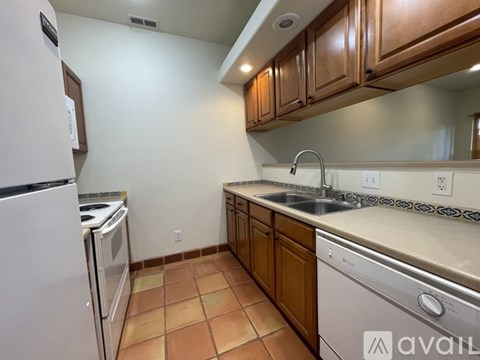 A kitchen with a white refrigerator, white oven, and white dishwasher.