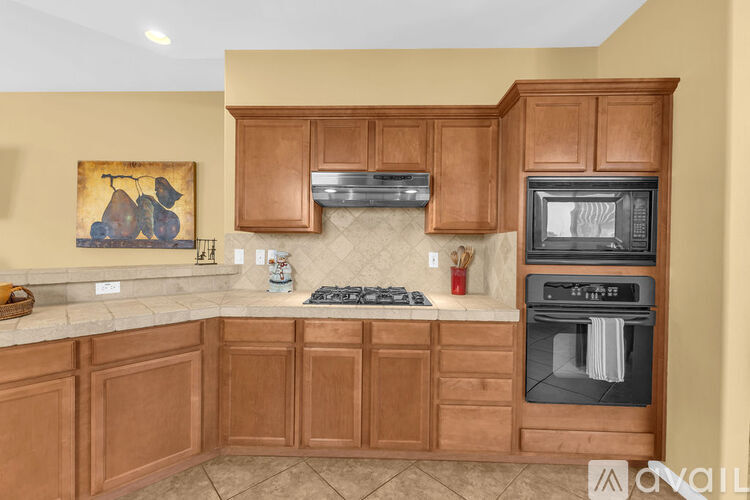 A kitchen with wooden cabinets and a stove top oven.