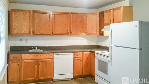 A kitchen with wooden cabinets and a white refrigerator.