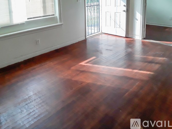 A room with a wooden floor and a white door.