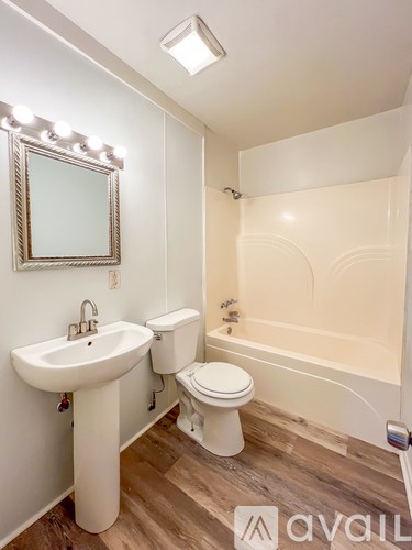 A bathroom with a sink, toilet, and bathtub.