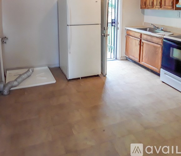 A kitchen with a white refrigerator and wooden floors.