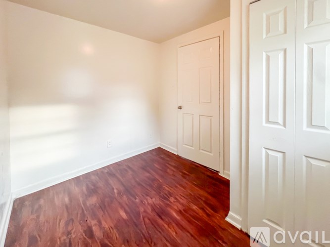 A room with a wooden floor and white walls.