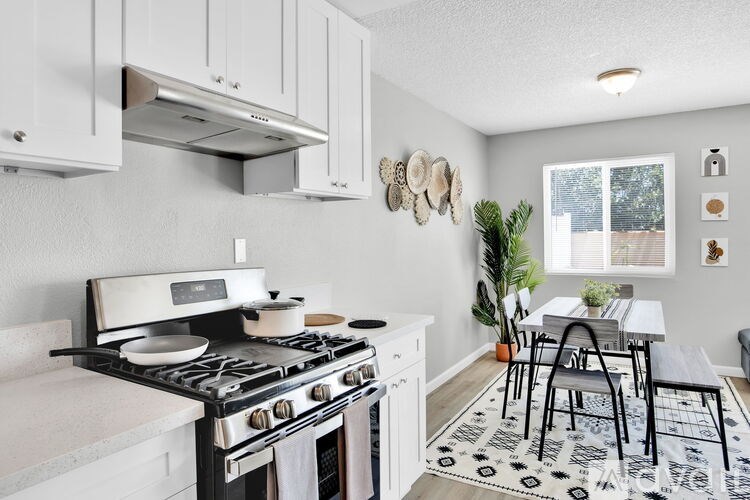 A modern kitchen with a black and white patterned rug on the floor.