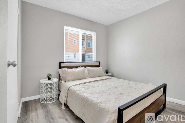 A bedroom with a large bed and a window overlooking a building.