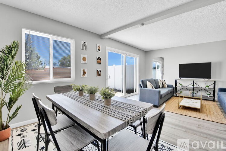 A modern dining room with a wooden table and chairs.