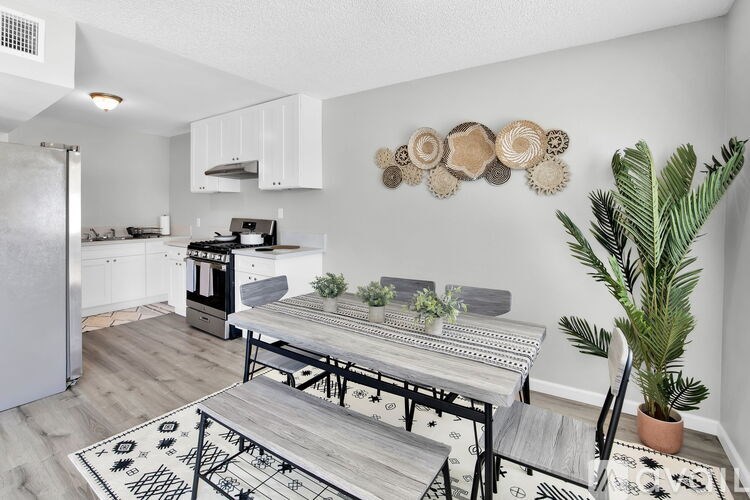 A modern kitchen with a dining table and chairs.